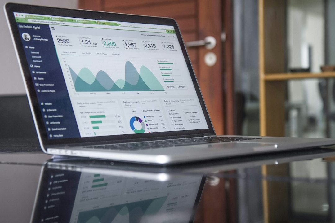 Laptop menampilkan grafik analisis keuangan dan transaksi digital